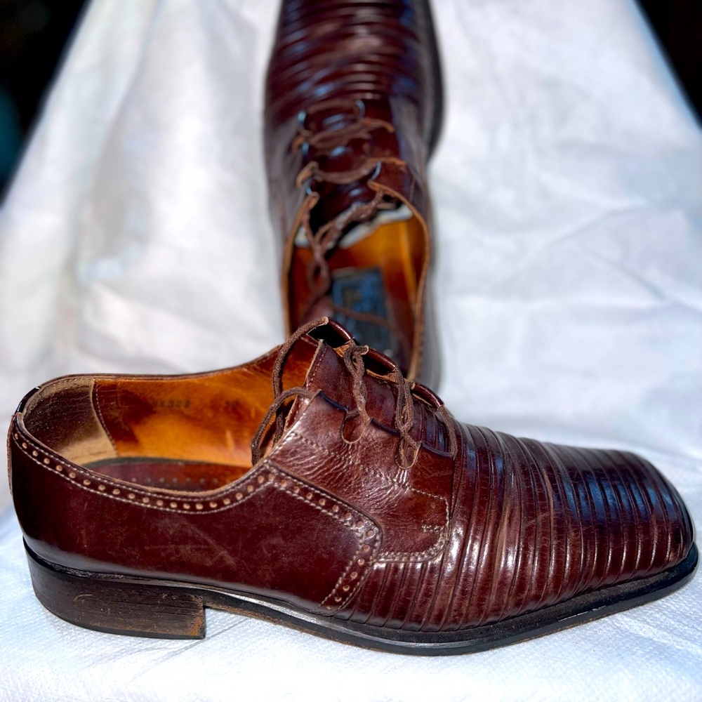 Men’s brown dress shoes.  Some visible wear.  Patterned brown leather